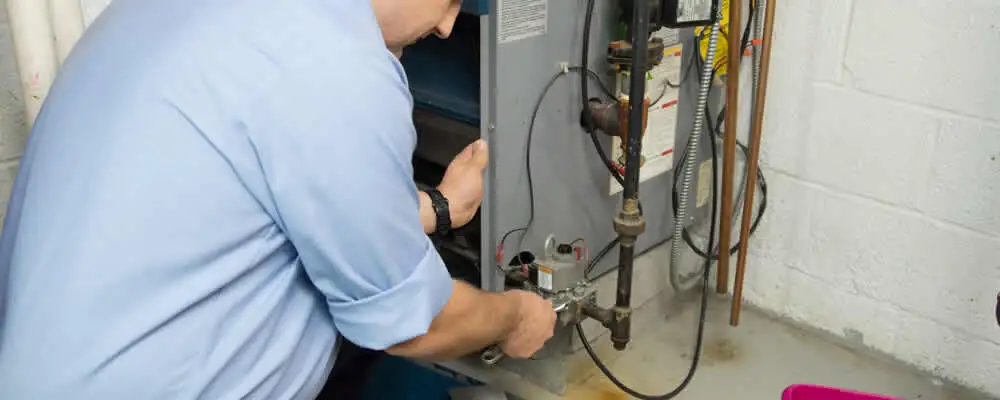 Furnace repair technician inspecting and servicing a home heating system in Mesa, AZ