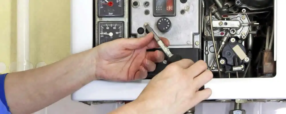Heating repair technician adjusting boiler controls and components in Mesa, AZ