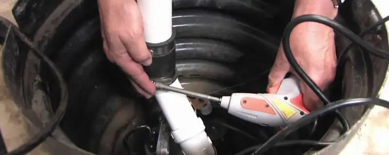 Sump pump installation technician connecting PVC discharge piping in Mesa, AZ
